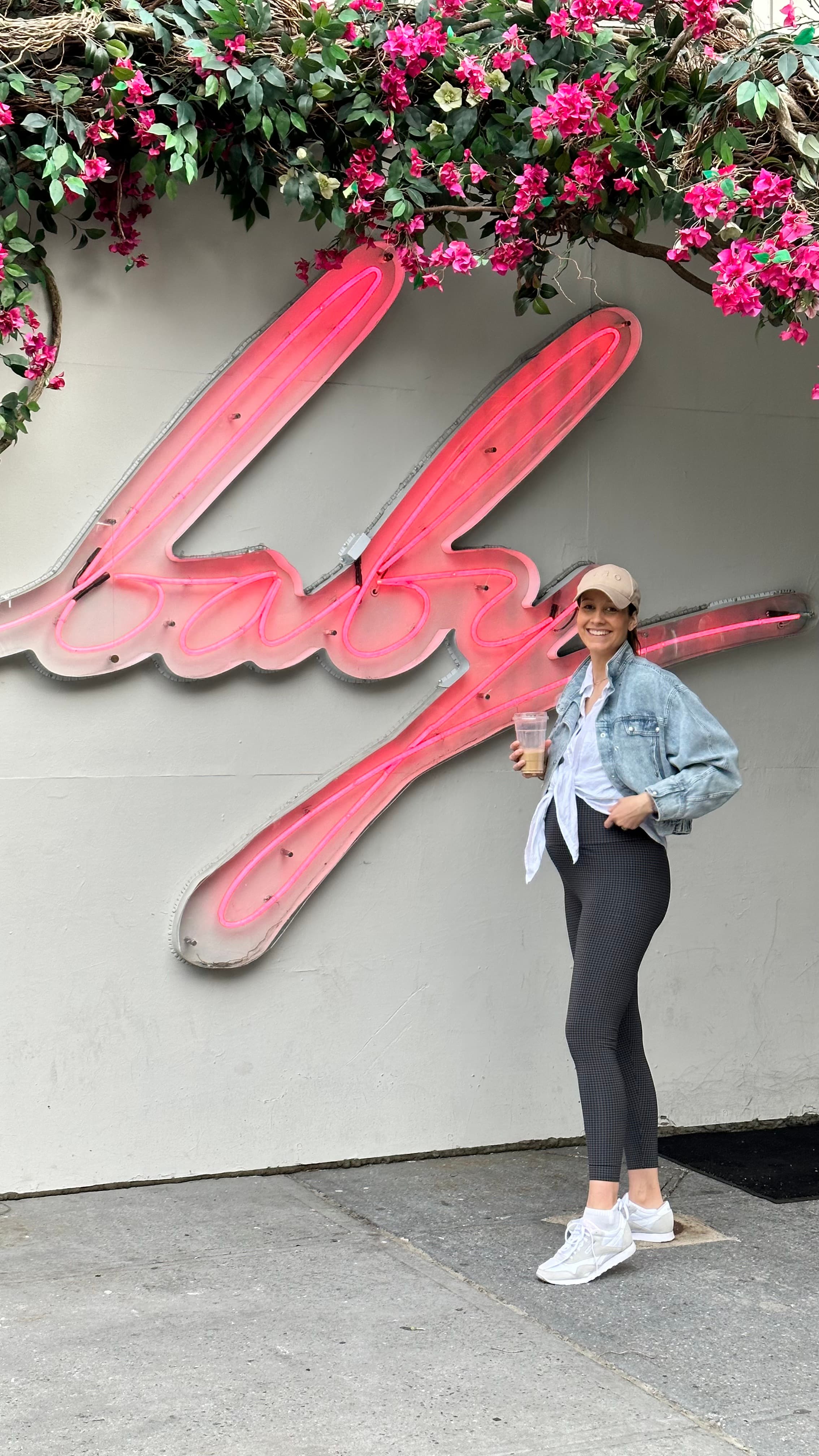 Sabrina vor pinkem Neon-baby-Schriftzug